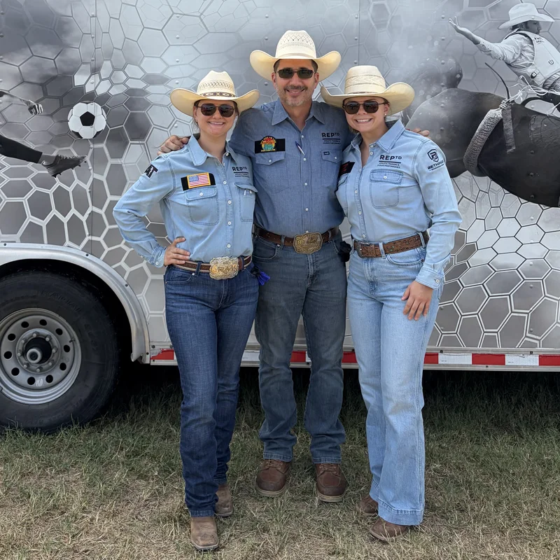 Three REPTD athletic trainers in western wear in front of the REPTD trailer